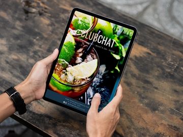 Hands holding tablet with the latest ClubChat open